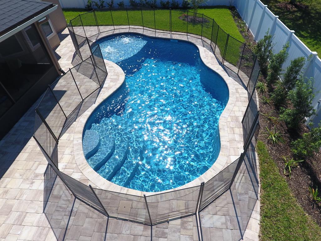 Aerial view of a freeform pool with a fence